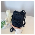 Mini sac à bandoulière en nylon noir avec nœud et sangle réglable tenu à la main - Noir
