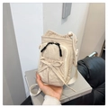 Beige nylon crossbody bag with bow detail and drawstring closure shown in hand - Khaki