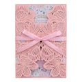Detail of pink laser-cut wedding invitation with elegant floral patterns and silk bow - Pink