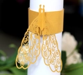 Macro view of a laser-cut gold peacock paper napkin ring for elegant wedding table decor - Gold Yellow