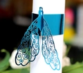 Macro detail of royal blue laser-cut peacock napkin ring with intricate hollow patterns - Reflective Blue