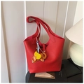 Détail d'un sac à main rouge en cuir grainé avec un pendentif d'éléphant coloré élégant - Rouge Avec Pendentif