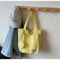 Détail d'un grand sac fourre-tout jaune avec une petite pochette ronde assortie - Jaune