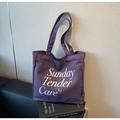 Detail van de paarse canvas draagtas met Sunday Tender Care TCT belettering - Paars