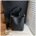 Détail du sac seau noir grainé avec logo embossé et finitions métalliques élégantes - Noir
