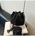 Detail of black bucket bag with woven texture, drawstring closure and silver chain strap - Black