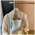 Sac seau bleu clair en cuir grainé avec une large bandoulière de style épuré - Bleu
