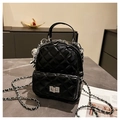 Macro view of black quilted patent leather backpack with silver chain and metal clasp - With Charm Style / Black