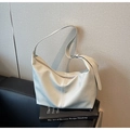 Detailed macro view of the cream white litchi grain texture on the soft hobo bag - Blue