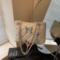 Beige quilted chain bag featuring a silver metal bow accent and leather-threaded strap - Off-white