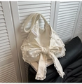 Détail d'un sac cabas en toile blanche avec un grand nœud et une bordure en dentelle - Blanc