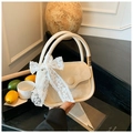 Detail of a beige PU leather handbag with a delicate lace bow and circular clasp - Off White
