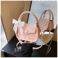 Detail of pink PU leather handbag featuring a white lace bow and adjustable strap - Pink