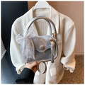 Detail of silver square bag featuring a large lace bow and shiny metallic ring handle - Silver