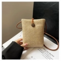 Close-up of woven straw phone bag with textured crochet pattern and round button closure - Khaki