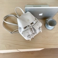 Mochila mini chic en cuero beige granulado con logo dorado y bolsillos delanteros con hebilla - Blanco