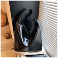 Detailansicht der schwarzen glänzenden Ledershopper-Tasche mit elegantem Licht und Schatten - Schwarz