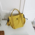 Minimalist yellow nylon tote bag with detachable black shoulder strap and metal logo - Yellow