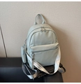 Detail of mint green PU leather backpack featuring lychee texture and woven straps - Green