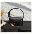 Dettaglio della borsa in pelle nera a grana litchi con borchie argentate e manico - Taglia unica / Nero