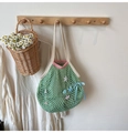 Detail der grünen Netztasche mit rosa Rand, Seestern-Anhänger und blauer Schleife - Grün