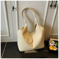 Vue détaillée de la texture du cuir grainé crème sur le sac cabas avec bandoulière - Blanc Cassé