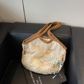 Grand sac cabas en maille tressée beige avec nœud bleu et charms coquillages sur sofa noir - Marron