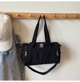 Detalle de una bolsa de lona de nailon negro con doble cremallera y asas de tela fuerte - Negro
