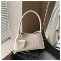 Detailed close-up of a woven beige shoulder bag with knot handle and leather charm - Off White