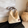 Off-white canvas tote bag with brown leather straps and hobo style minimalist design - White
