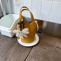 Ginger yellow bucket bag in textured faux leather with floral charm for daily commuting - Yellow