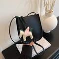 Elegant black lychee leather bucket bag with colorful horse charm and shoulder strap - Black