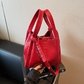 Rode bucketbag met krokodillenprint, dubbele handvatten en verstelbare schouderriem - Bordeauxrood