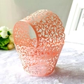 Detail of laser-cut vine patterns on pink cupcake wrapper for party decor - Pink