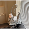 Detailed macro view of silver metallic tote bag with magnetic flap and plush bear charm - With Charm / Silver