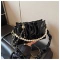 Detailed view of black patent leather pleated cloud bag with elegant pearl chain handle - Black