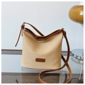 Détail du sac seau en paille tressée avec garniture en cuir marron et boucles argent - Marron