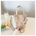 Detail of cream crocodile texture tote bag with puppy charm and adjustable strap - With Charm / Khaki