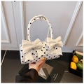 Primer plano de bolso blanco con lunares, detalles de lazos dobles y acabado brillante - Blanco
