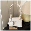Détail du sac seau crème avec poignée nouée et breloque en forme de cœur assortie - Blanc