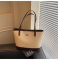 Détail du sac cabas tissé montrant la texture paille beige et les finitions en cuir brun - Marron