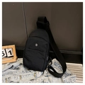 Gros plan du sac bandoulière en nylon noir avec logo métallique et large bandoulière - Noir
