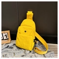 Détail d'un sac de poitrine en nylon jaune vif avec poche principale zippée et sangle large - Jaune