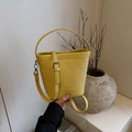 Borsa a secchiello gialla con trama a grana litchi e manico in un set minimalista - Giallo senza pendente