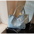 Détail du cabas en denim bleu clair avec breloques papillon et pendentif en dentelle - Bleu ciel avec pendentif