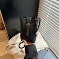 Minimalist black pebble leather bucket bag with silver buckle and thin woven strap - Black