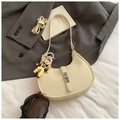 Chic beige dumpling bag in lychee texture leather with silver lock and cartoon pendant - Beige With Charm