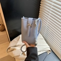 Minimalist light blue bucket phone bag with litchi grain texture and metallic charm - Blue