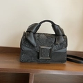 Chic black snake-patterned crossbody bag featuring a striking metal buckle and knotted handle - Black