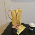 Yellow litchi texture mini bucket phone bag with silver buckle and crossbody strap - Yellow